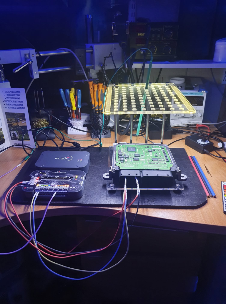 ECU connected to programming equipment on the Revelectronics workbench